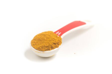 Curry Powder into a teaspoon. Measuring spoon on white backgroundの写真素材