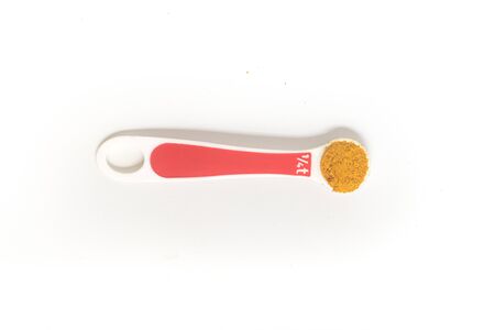 Curry Powder into a teaspoon. Measuring spoon on white backgroundの写真素材