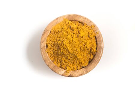 Curry Powder into a wooden bamboo bowl on white backgroundの写真素材