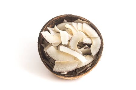 Shaved Coconut into a coconut bowl over white backgroundの写真素材