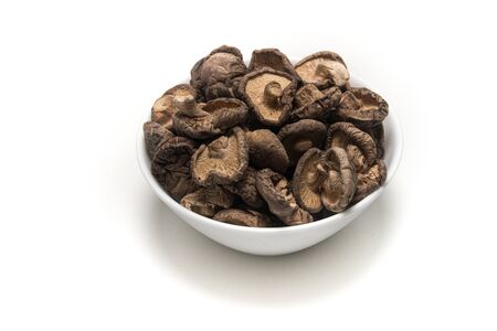 Dried Shitake Mushroom   into a wooden bowl on white backgroundの写真素材