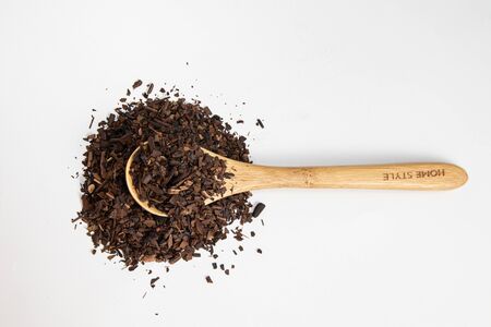 Toasted Erva-Mate into a measuring spoon on white backgroundの写真素材