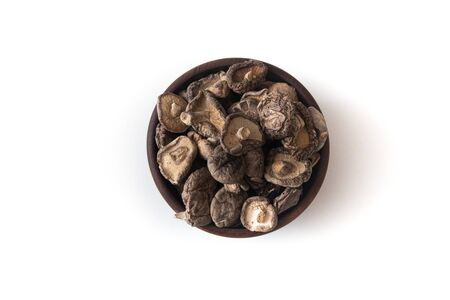 Dried Shitake Mushroom   into a wooden bowl on white backgroundの写真素材