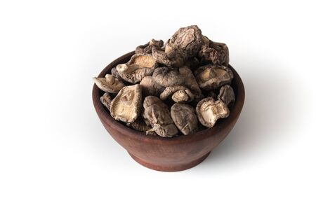 Dried Shitake Mushroom   into a wooden bowl on white backgroundの写真素材