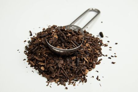 Toasted Erva-Mate into a measuring spoon on white backgroundの写真素材