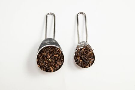 Toasted Erva-Mate into a measuring spoon on white backgroundの写真素材