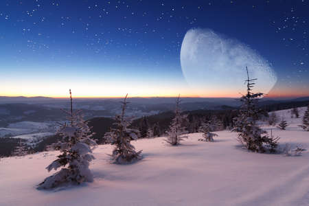 Winter mountains landscape. Night landscape with stars on sky. Amazing view at mountains and sky full of stars at night. Beautiful winter night in mountains. High quality photoの写真素材