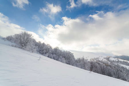 Beautiful landscape with the Carpathian mountains. Snow-capped mountain peaks from a height. A wonderful sky covers the snowy winter mountains. Ukraineの写真素材