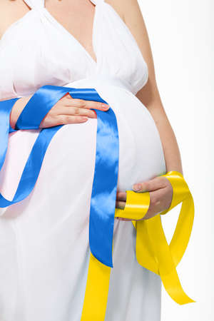 The War in Ukraine, Ukrainian conflict background. The Ukrainian flag is painting on the belly of a pregnant woman. Peace, pacifism, activism, no war and support conceptの写真素材