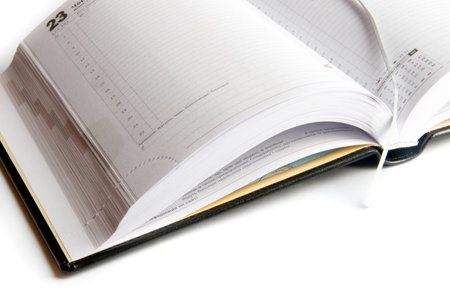 Business diary with a pen on a white backgroundの写真素材