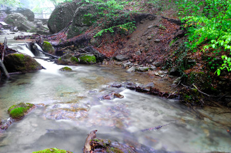 Long exposure view of a hidden river in Crimea, Ukraine. A stone set against a blurred water pattern is ideal for background use.の写真素材