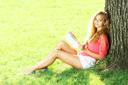 Photo of cute blond female laying down on chamomile field and looking up in sky, sunny day, warm weather, spring holiday and vacation, pretty woman enjoying beautiful nature, daisy fieldの写真素材