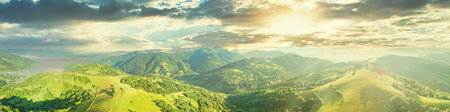 Aerial view of the endless lush pastures of the Carpathian expanses and agricultural land. Cultivated agricultural field. Rural mountain landscape at sunset. Ukraine.の写真素材