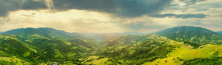 Aerial view of the endless lush pastures of the Carpathian expanses and agricultural land. Cultivated agricultural field. Rural mountain landscape at sunset. Ukraine.の写真素材