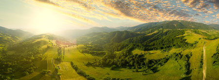 Aerial view of the endless lush pastures of the Carpathian expanses and agricultural land. Cultivated agricultural field. Rural mountain landscape at sunset. Ukraine.の写真素材
