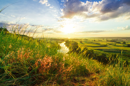A beautiful valley with a river, blue sky with large clouds and bright sun. Aerialの写真素材