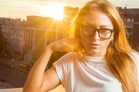 Happy smiling girl wearing purple sunglasses, yellow turtleneck, golden wrist watch, hoop earrings posing in street. Autumn fashion, advertising concept. Copy, empty space for textの写真素材