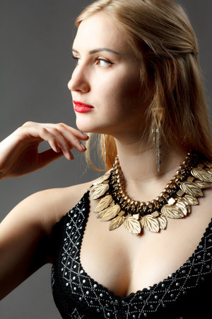 Woman putting on diamond earrings. Caucasian beauty lady trying and shopping jewelry.の写真素材