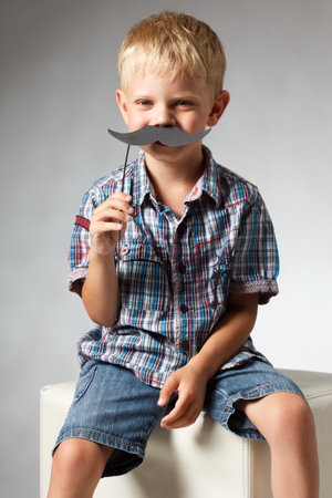 Cute boy wearing shirt hat and mustacheの写真素材