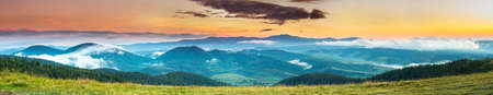 Autumn landscape with fog in the mountains. Fir forest on the hills.の写真素材