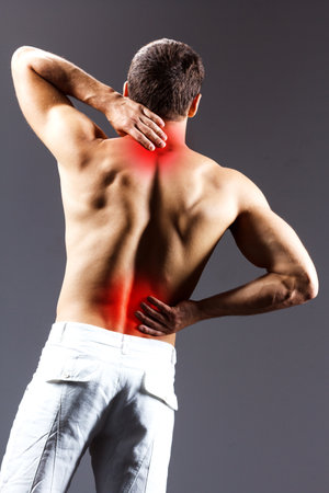 pain relief, sport, bodybuilding, strength and people concept - young man standing over black backgroundの写真素材