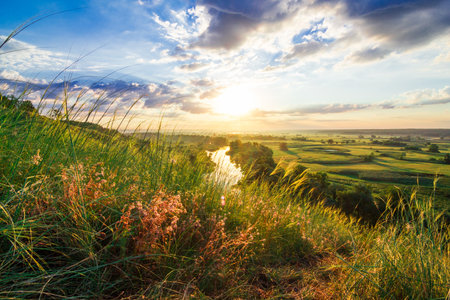 A beautiful valley with a river, blue sky with large clouds and bright sun. Aerialの写真素材