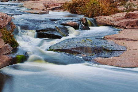 Beautiful mountain river flowing over rocks. Flow of water in mountain river close upの写真素材