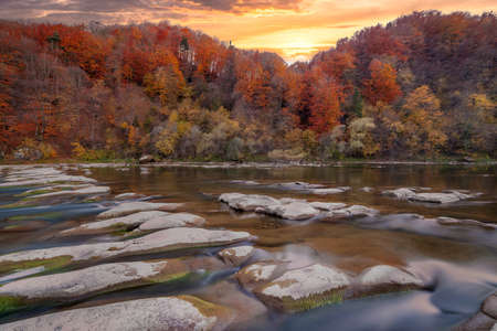 View of the waterfall in autumn. Waterfall in autumn colors. Mountain river in the autumn landscape. Ukraine, river Stryj.の写真素材
