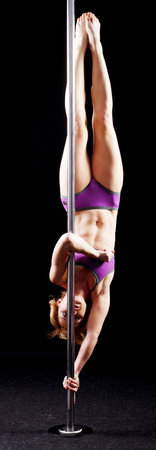The strong and graceful young girl performing acrobatic exercises on pylonの写真素材