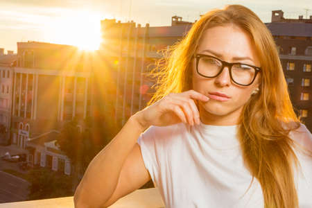 Happy smiling girl wearing purple sunglasses, yellow turtleneck, golden wrist watch, hoop earrings posing in street. Autumn fashion, advertising concept. Copy, empty space for textの写真素材