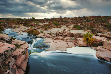 Beautiful mountain river flowing over rocks. Flow of water in mountain river close upの写真素材