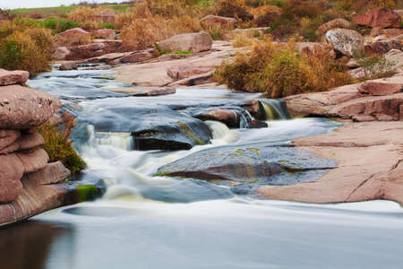 Beautiful mountain river flowing over rocks. Flow of water in mountain river close upの写真素材