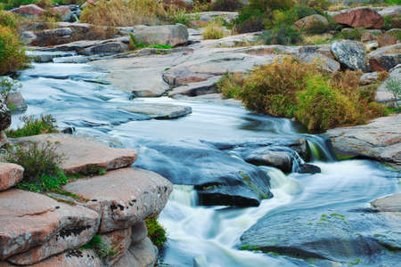 Beautiful mountain river flowing over rocks. Flow of water in mountain river close upの写真素材