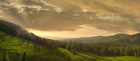 Wide-angle panoramic shot of beautiful meadows, hills and trees in Synevyrska glade next to Synevyr lake. Majestic and wonderful landscapes of the Carpathian mountains in Ukraineの写真素材