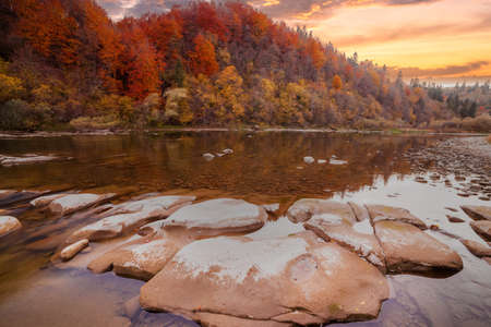 View of the waterfall in autumn. Waterfall in autumn colors. Mountain river in the autumn landscape. Ukraine, river Stryj.の写真素材