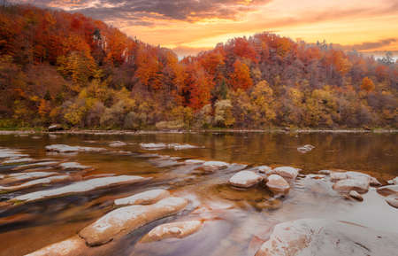 View of the waterfall in autumn. Waterfall in autumn colors. Mountain river in the autumn landscape. Ukraine, river Stryj.の写真素材