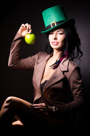 Halloween. A terrible wicked witch holds a poisoned apple in her hands, standing in her lair among the cobwebs. Evil black magic.の写真素材