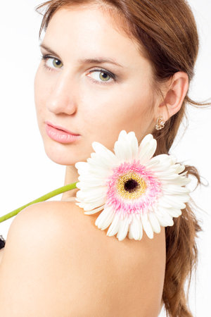 Portrait of beautiful woman with bright make up holding pink daisy in handsの写真素材