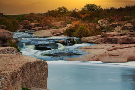 Beautiful mountain river flowing over rocks. Flow of water in mountain river close upの写真素材