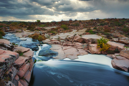 Beautiful mountain river flowing over rocks. Flow of water in mountain river close upの写真素材
