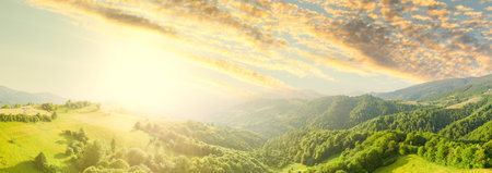 Aerial view of the endless lush pastures of the Carpathian expanses and agricultural land. Cultivated agricultural field. Rural mountain landscape at sunset. Ukraine.の写真素材