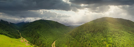 Wide-angle panoramic shot of beautiful meadows, hills and trees in Synevyrska glade next to Synevyr lake. Majestic and wonderful landscapes of the Carpathian mountains in Ukraineの写真素材