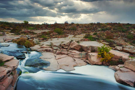 Beautiful mountain river flowing over rocks. Flow of water in mountain river close upの写真素材