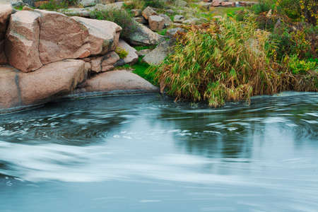 Beautiful mountain river flowing over rocks. Flow of water in mountain river close upの写真素材