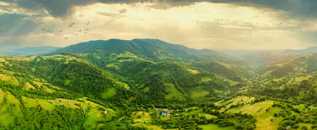 Aerial view of the endless lush pastures of the Carpathian expanses and agricultural land. Cultivated agricultural field. Rural mountain landscape at sunset. Ukraine.の写真素材