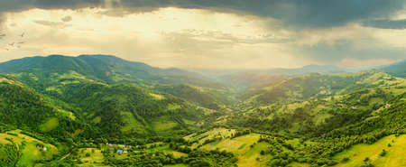 Aerial view of the endless lush pastures of the Carpathian expanses and agricultural land. Cultivated agricultural field. Rural mountain landscape at sunset. Ukraine.の写真素材