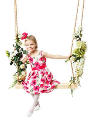 Beautiful little girl swinging on a swing. The concept of family happiness, summer holidays. Isolated on white background.の写真素材