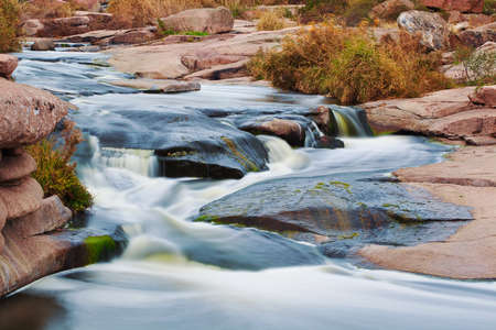 Beautiful mountain river flowing over rocks. Flow of water in mountain river close upの写真素材