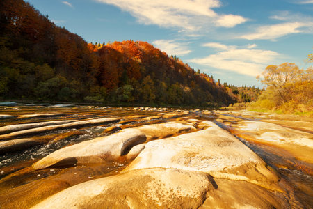 View of the waterfall in autumn. Waterfall in autumn colors. Mountain river in the autumn landscape. Ukraine, river Stryj.の写真素材