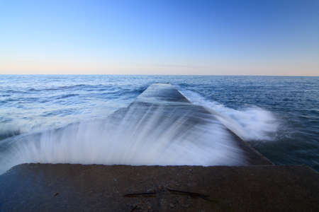 A massive breakwater crashing into the depths of the sea and protecting the seashore from the elements of the sea. Wonderful sunset on the sea. Pure and wonderful nature of Crimea. Ukraine.の写真素材